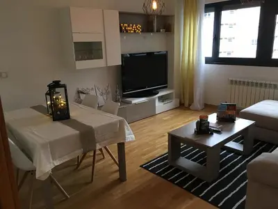 a living room with a table and a television at Alojamiento La Rosaleda in Ponferrada