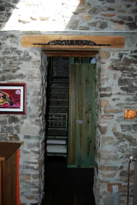 a wooden door in a stone building with stairs at MIL MADREÑAS ROJAS in Salientes