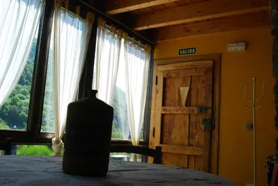 a vase sitting on a table in a room with windows at MIL MADREÑAS ROJAS in Salientes
