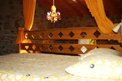a bedroom with a bed with a chandelier at MIL MADREÑAS ROJAS in Salientes