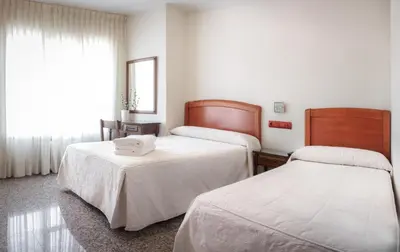 a hotel room with two beds and a window at San Miguel in Ponferrada