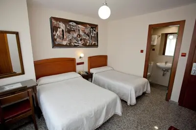 a hotel room with two beds and a sink at San Miguel in Ponferrada