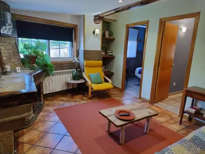 a living room with a yellow chair and a table at Casa Bartulo in Castrofeito