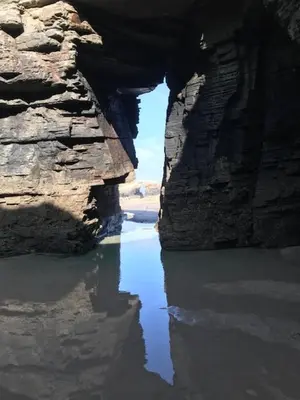 a view of a body of water between two rocks at Apartamentos Las Fuentes in Castropol