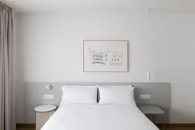 a bedroom with a white bed and a picture on the wall at Apartamentos Forum Ceao in Lugo