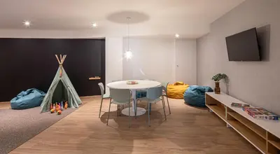 a room with a table and chairs and a play area at Apartamentos Forum Ceao in Lugo