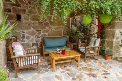 a patio with two chairs and a table at O Remanso Dos Patos in Penalba