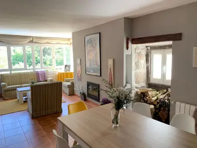 a dining room and living room with a table and chairs at O Remanso Dos Patos in Penalba