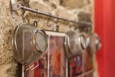 a shower head hanging on a stone wall at O Remanso Dos Patos in Penalba