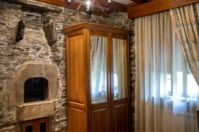 a wooden cabinet in a room with a stone wall at Apartamentos Rurales Las Mestas in Puenteciella