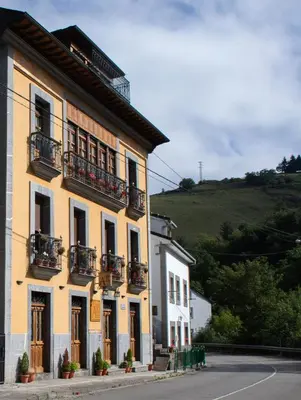 a yellow building with balconies on a street at Apartamentos Rurales Las Mestas in Puenteciella