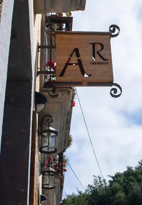 a sign hanging from the side of a building with lights at Apartamentos Rurales Las Mestas in Puenteciella