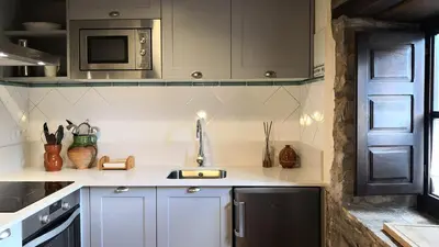 a kitchen with a sink and a microwave at Fogar Mozárabe in Peñalba de Santiago