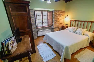 a bedroom with a bed and a television in it at A Casoa in Santa Eulalia de Oscos