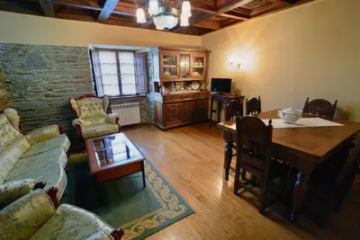 a living room with a couch a table and a dining room at A Casoa in Santa Eulalia de Oscos