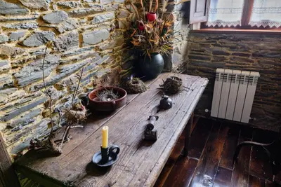 a wooden table with a candle and plants on it at A Casoa in Santa Eulalia de Oscos