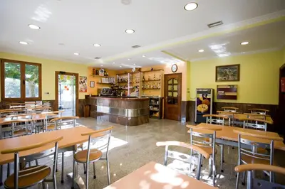 a restaurant with tables and chairs and a counter at Hostal La Casilla in Guitiriz