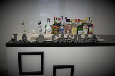 a shelf with bottles of alcohol on a wall at Hostal La Casilla in Guitiriz