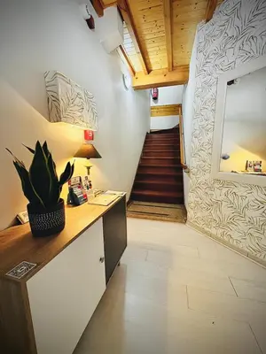 a hallway with a desk and a staircase with a mirror at Hostal As Margaritas in Santiago de Compostela