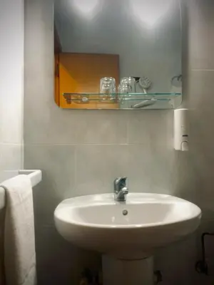 a bathroom with a white sink and a mirror at Hostal As Margaritas in Santiago de Compostela