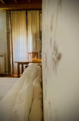 a bedroom with a bed and a wooden table at Hostal As Margaritas in Santiago de Compostela