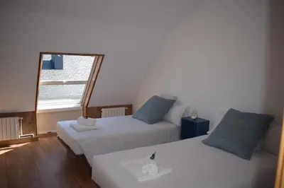 a room with two beds and a window at La Casa de Manuel in Portomarin