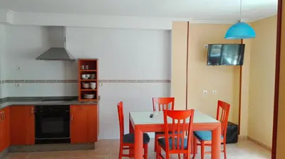 a kitchen with a table and chairs and a stove at Viviendas Turisticas Tapia in Tapia de Casariego