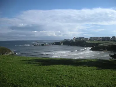 a view of the ocean from a field of grass at Viviendas Turisticas Tapia in Tapia de Casariego