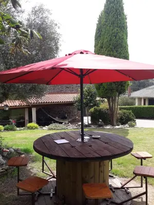 a table with a red umbrella on top of it at Casa Rural Oza dos Ríos in Oza dos Ríos
