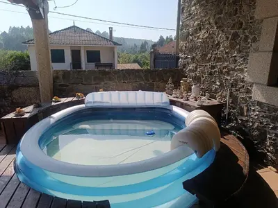 a large plunge pool in a yard with a house at Casa Rural Oza dos Ríos in Oza dos Ríos