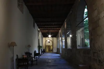 an empty hallway of a building with an archway at Hospedería San Martín Pinario in Santiago de Compostela