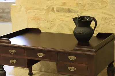 a black vase sitting on top of a wooden dresser at Hospedería San Martín Pinario in Santiago de Compostela