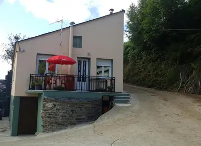 a house with a balcony with a red umbrella at Casa de Forno in Queijadoiro
