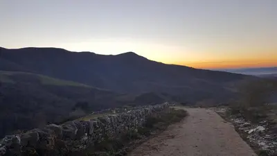 a dirt road with a stone wall on a mountain at Casa de Forno in Queijadoiro
