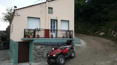 a four wheeler parked in front of a house at Casa de Forno in Queijadoiro