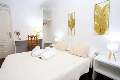 a bedroom with a white bed with white pillows at Pensión As Burgas in Caldas de Reis