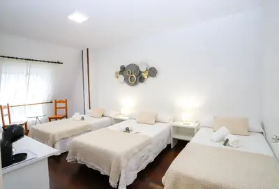 a room with three beds and a sink in it at Pensión As Burgas in Caldas de Reis