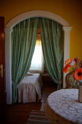 a bedroom with a bed and a window with curtains at Casa Maricuelo in Castropol