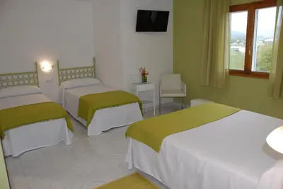 a hotel room with two beds and a television at Hotel Playa de las Catedrales in Reinante
