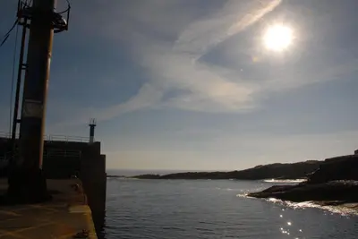 a body of water with the sun in the sky at Hotel Playa de las Catedrales in Reinante