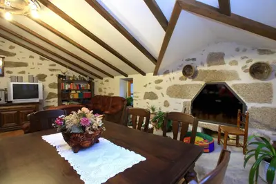 a dining room with a table and a fireplace at Hotel Rústico Casa Franco in Adelán