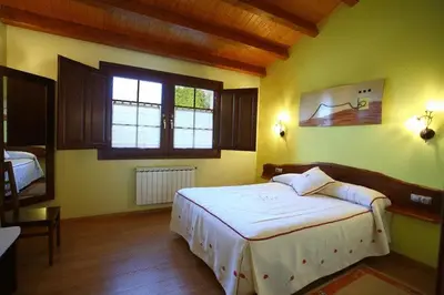 a bedroom with a large white bed in a room at Hotel Rústico Casa Franco in Adelán
