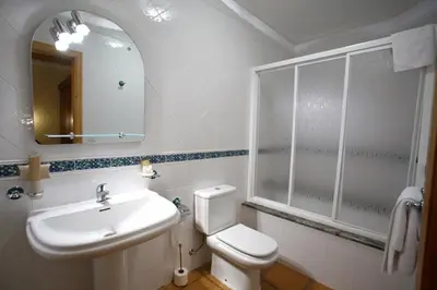 a bathroom with a sink and a toilet and a mirror at Hotel Rústico Casa Franco in Adelán