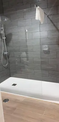 a bathroom with a shower with a glass door at Hotel O Camiño in O Barco de Valdeorras