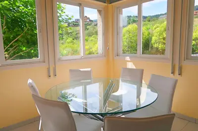 a dining room with a glass table and chairs at Hotel O Camiño in O Barco de Valdeorras