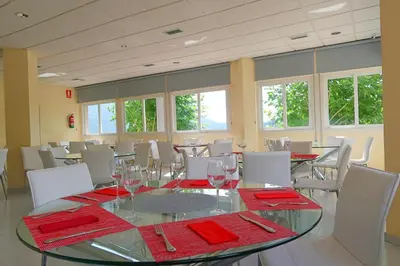 a dining room with a glass table and white chairs at Hotel O Camiño in O Barco de Valdeorras