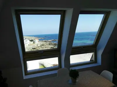 three windows in a room with a table and the ocean at San Ciprian Atico Playa by I Love Norte in San Ciprián