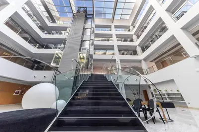 a staircase in a building with escalators andwindows at Hotel Ciudad de Ponferrada, Ascend Hotel Collection in Ponferrada