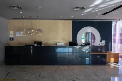 a lobby with a reception desk and a mirror at Hotel Ciudad de Ponferrada, Ascend Hotel Collection in Ponferrada
