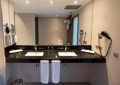 a hotel bathroom with two sinks and a shower at Hotel Ciudad de Ponferrada, Ascend Hotel Collection in Ponferrada